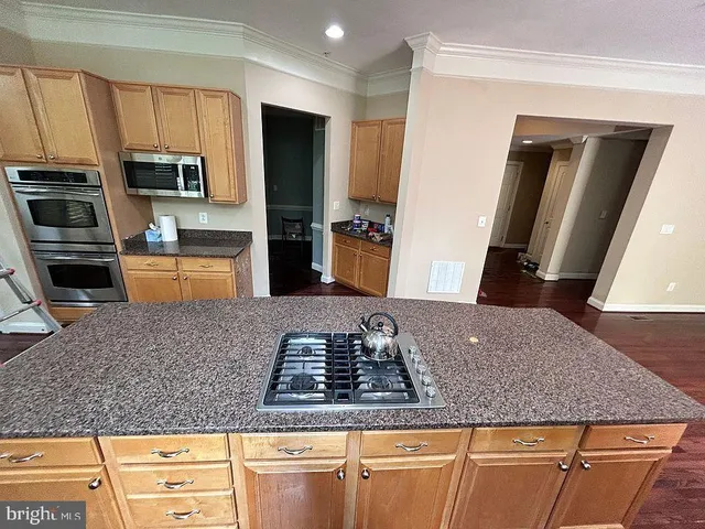 a kitchen with stainless steel appliances granite countertop a sink stove microwave and refrigerator