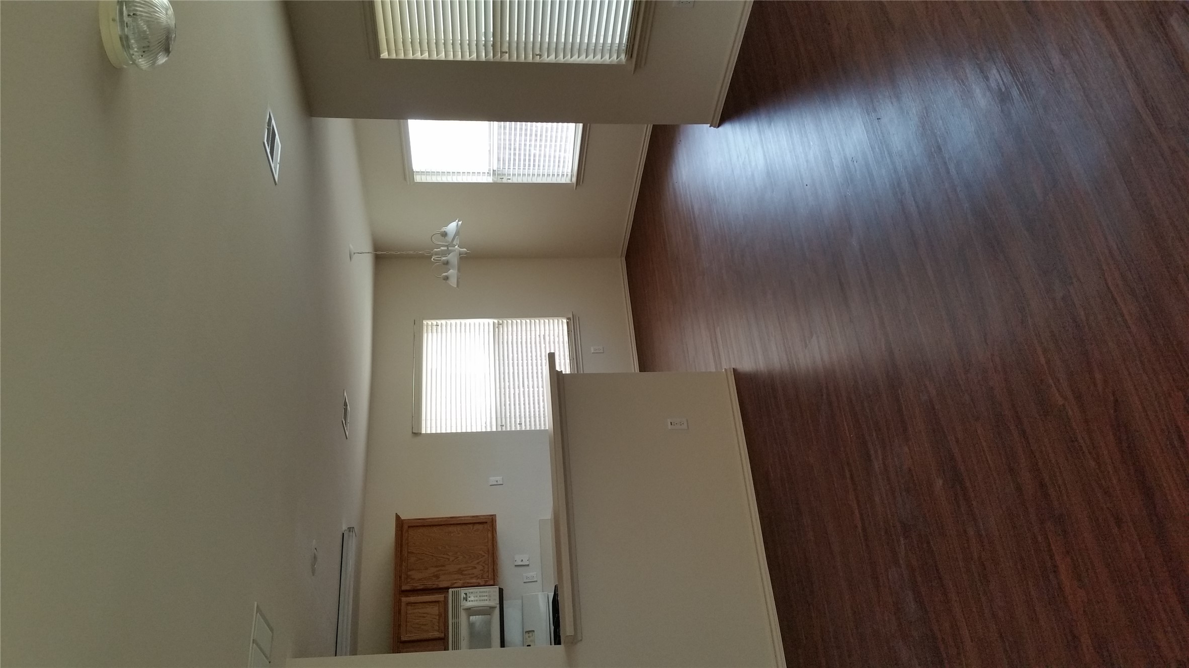 1324 Peppermint Trail Pflugerville, TX 78660 - Photo 10 of 33 Unfurnished living room featuring dark wood finished floors and suspended lighting