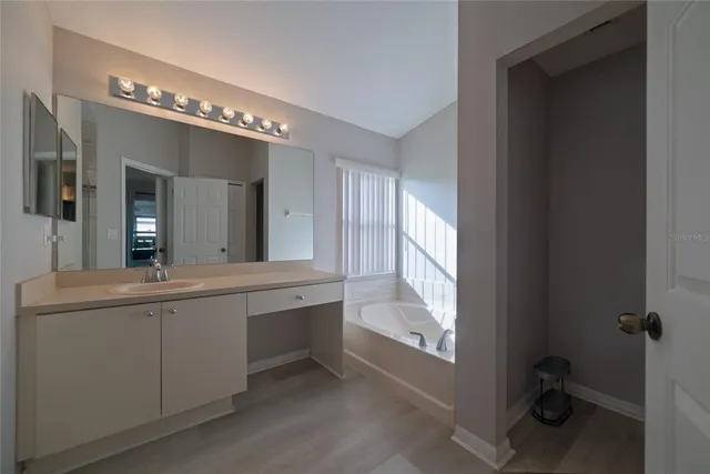 a bathroom with a sink shower and mirror