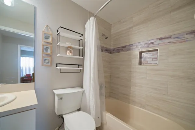 a view of a house with a yard and a large tree