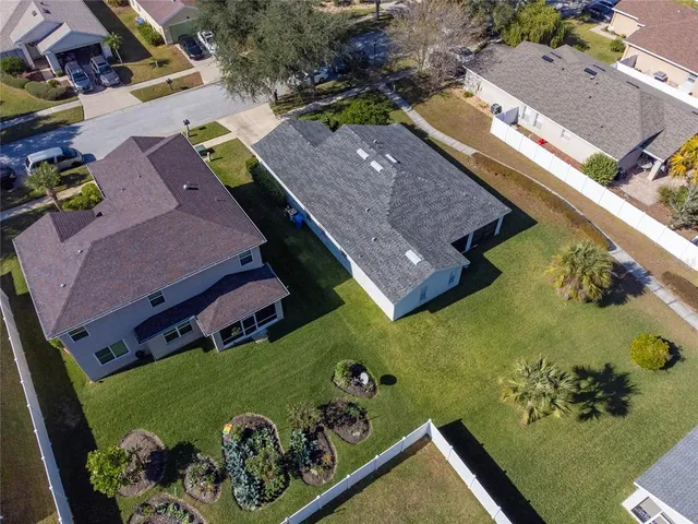 an aerial view of a house with a yard and large tree