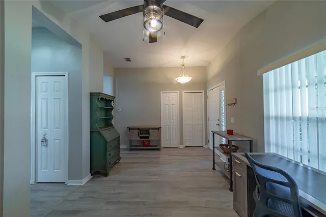 a living room with furniture kitchen area and a wooden floor