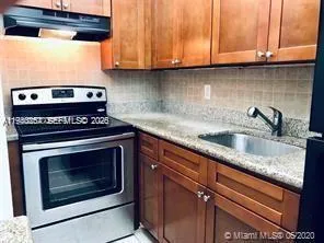 a kitchen with granite countertop a stove a sink and dishwasher