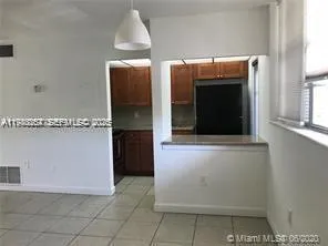a view of kitchen with cabinets and refrigerator