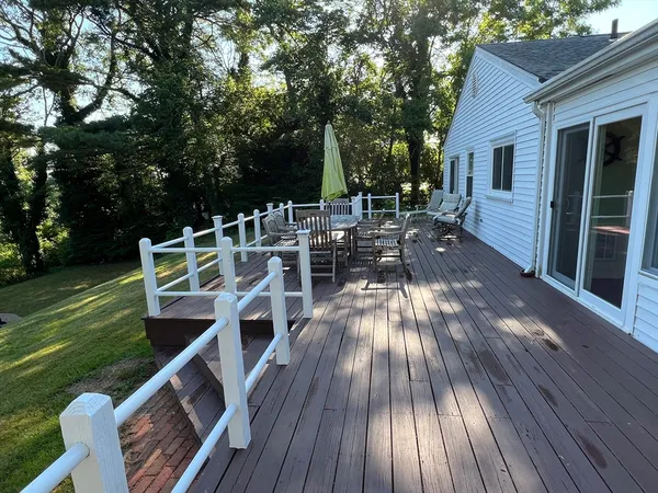 a view of deck with table and chairs a barbeque with wooden floor and fence