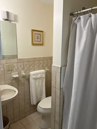 a white toilet sitting next to a bathroom sink