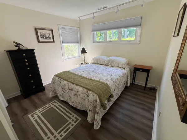 a spacious bedroom with a bed and a dresser