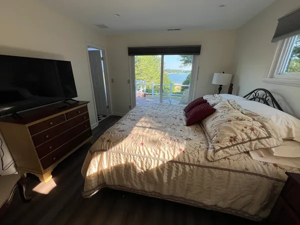 a bedroom with a bed window and flat screen tv
