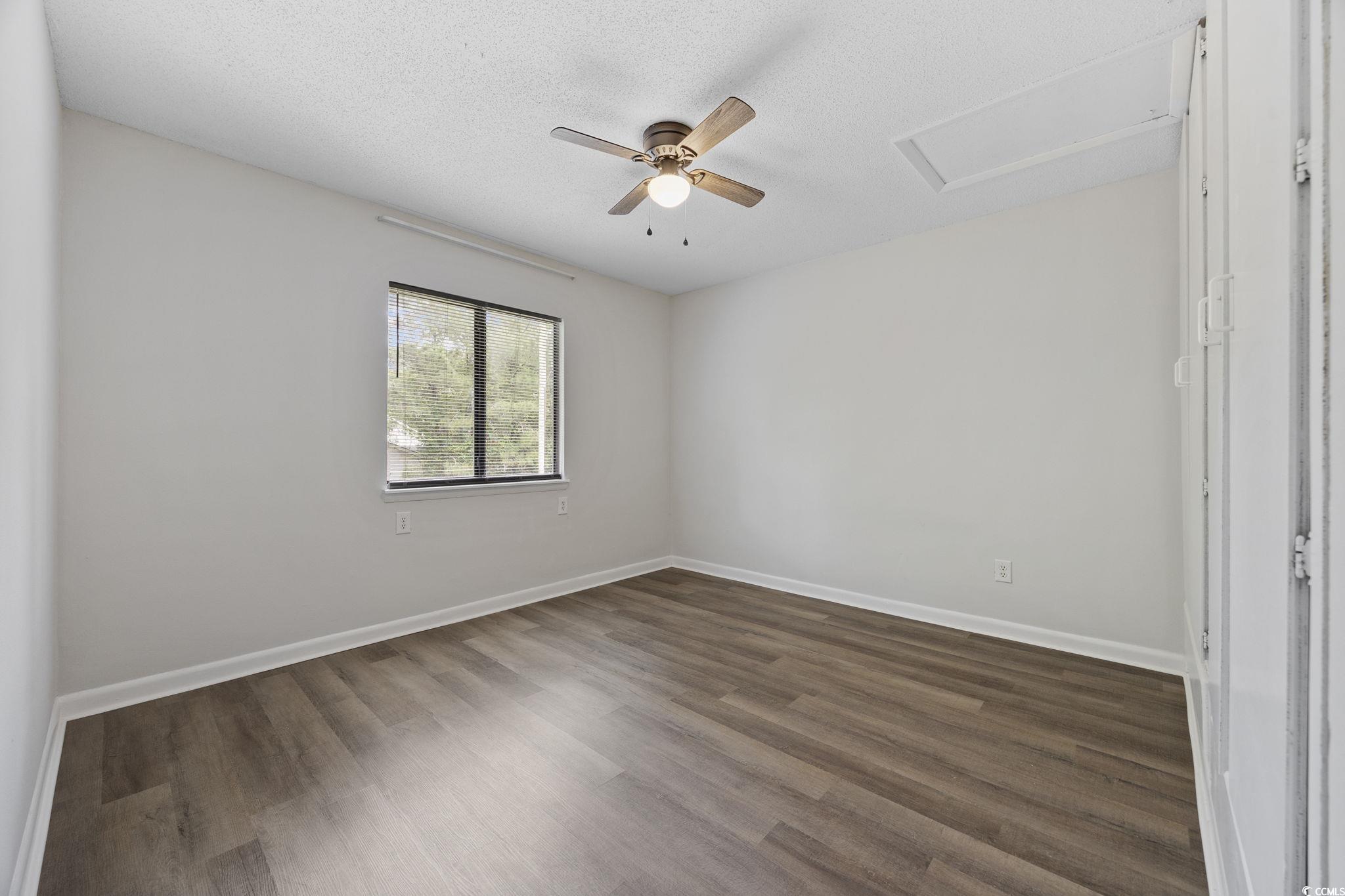 3555 Highway 544, Unit 8H Conway, SC 29526 - Photo 13 of 22 Spare room featuring attic access, dark wood finished floors, a ceiling fan, and a textured ceiling