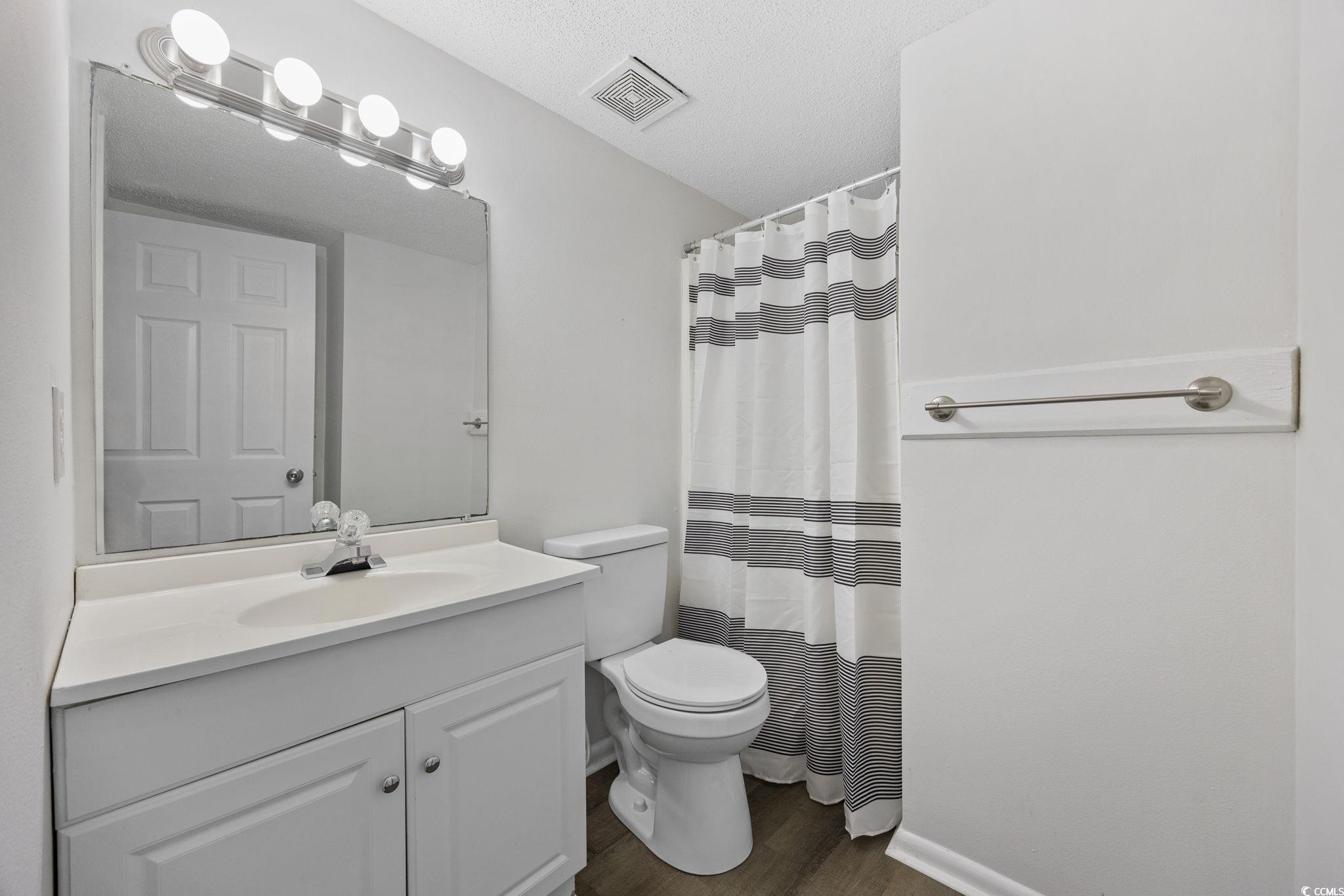 3555 Highway 544, Unit 8H Conway, SC 29526 - Photo 15 of 22 Bathroom with wood finished floors, vanity, a shower with curtain, and a textured ceiling