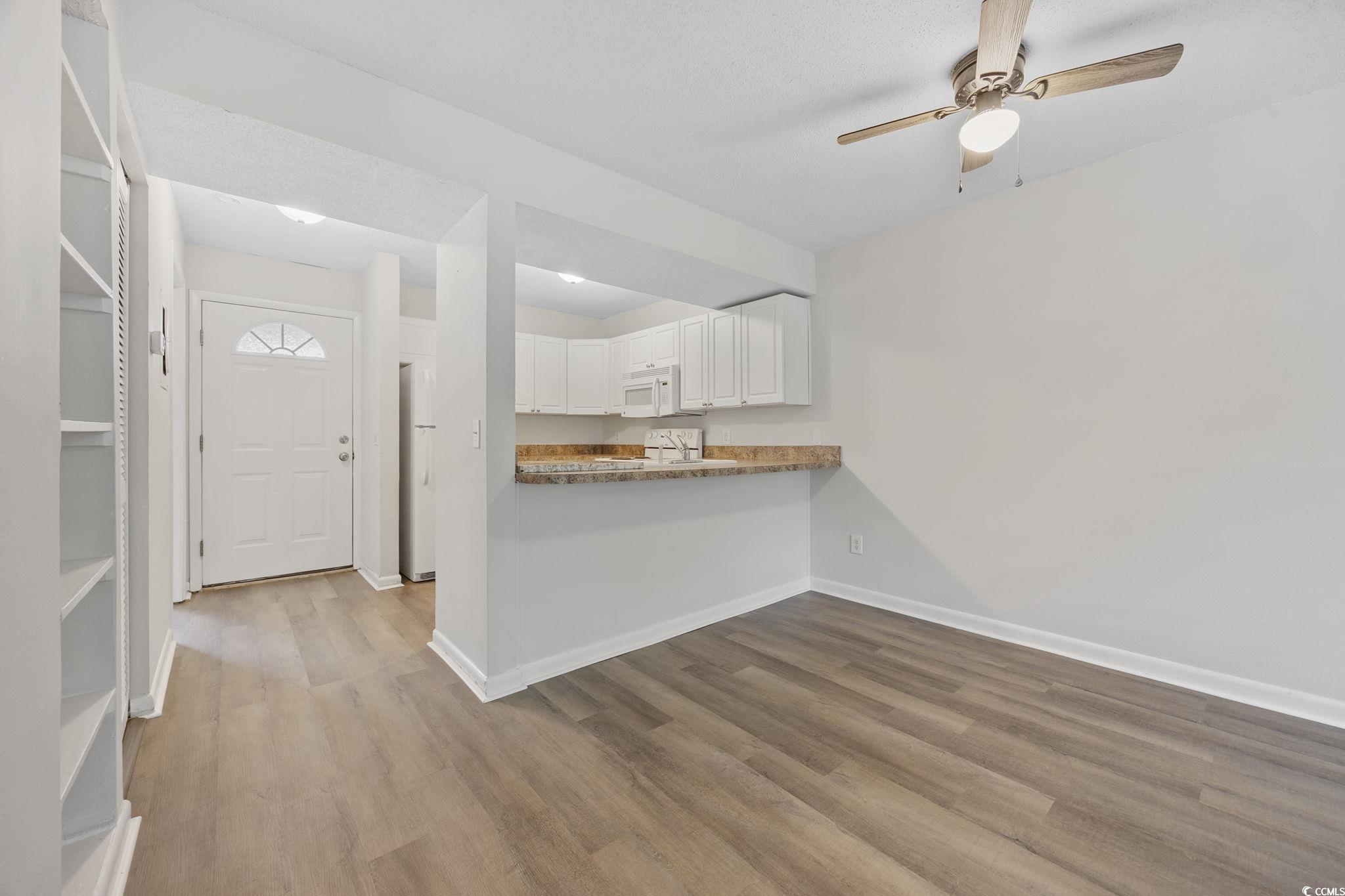 3555 Highway 544, Unit 8H Conway, SC 29526 - Photo 3 of 22 Kitchen featuring white appliances, wood finished floors, white cabinets, and a ceiling fan