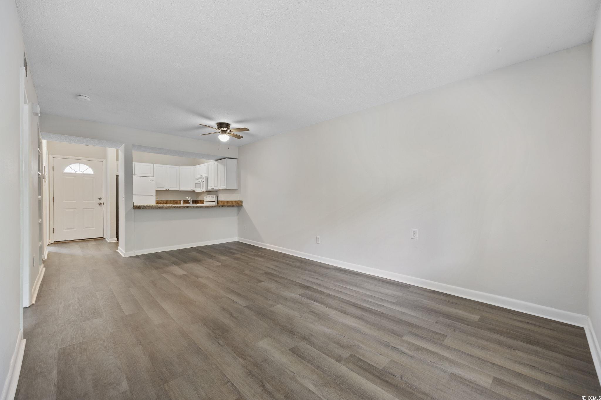 3555 Highway 544, Unit 8H Conway, SC 29526 - Photo 4 of 22 Unfurnished living room with ceiling fan and dark wood-style floors