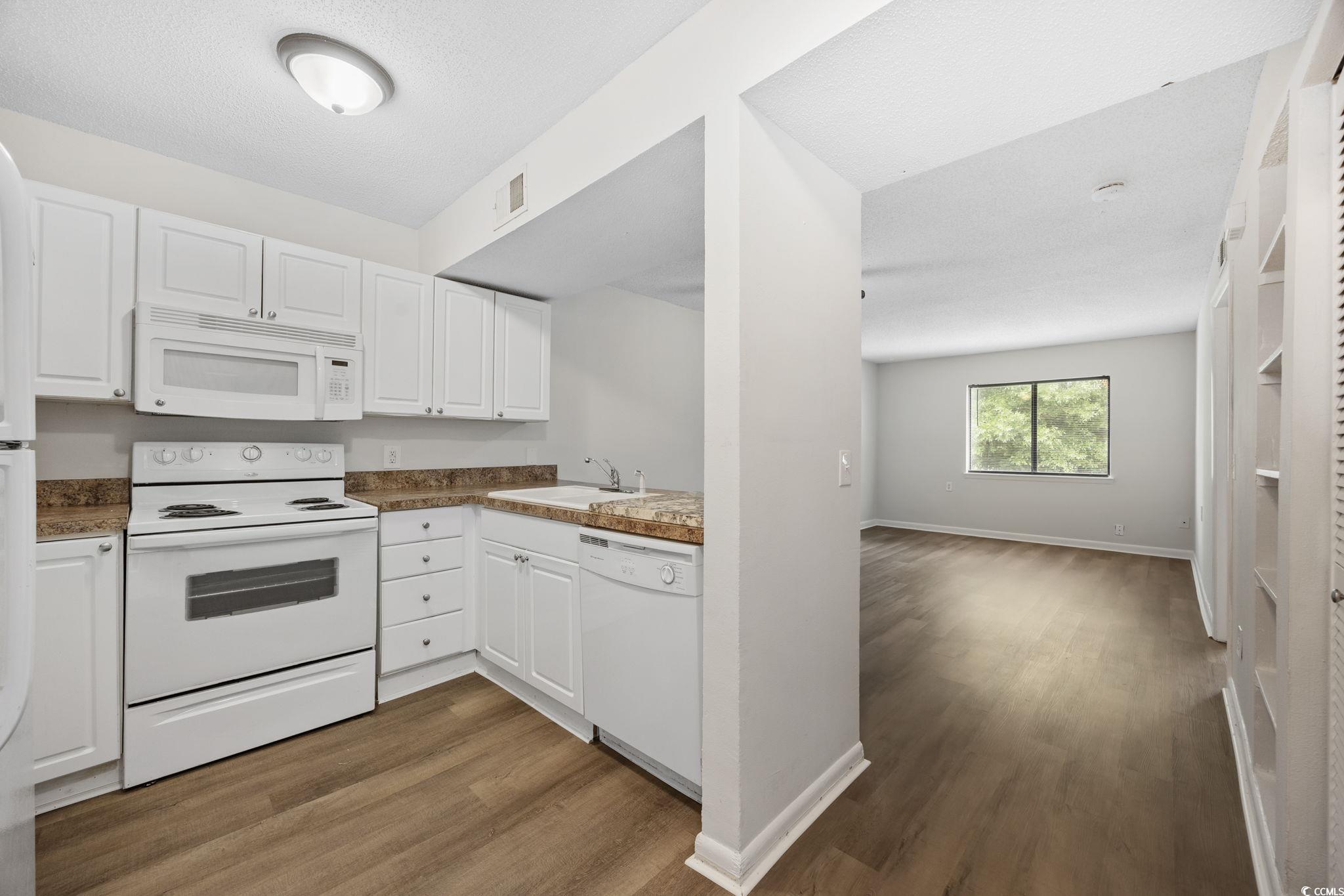 3555 Highway 544, Unit 8H Conway, SC 29526 - Photo 9 of 22 Kitchen with white appliances, dark wood-style floors, and white cabinets