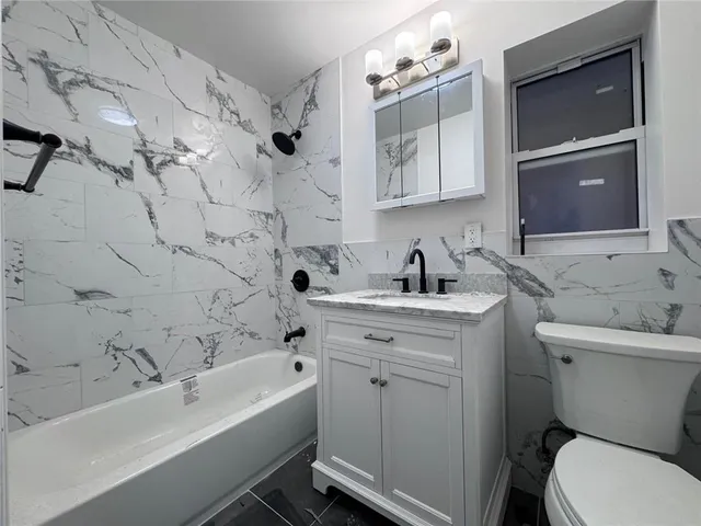 a bathroom with a sink mirror toilet and bathtub