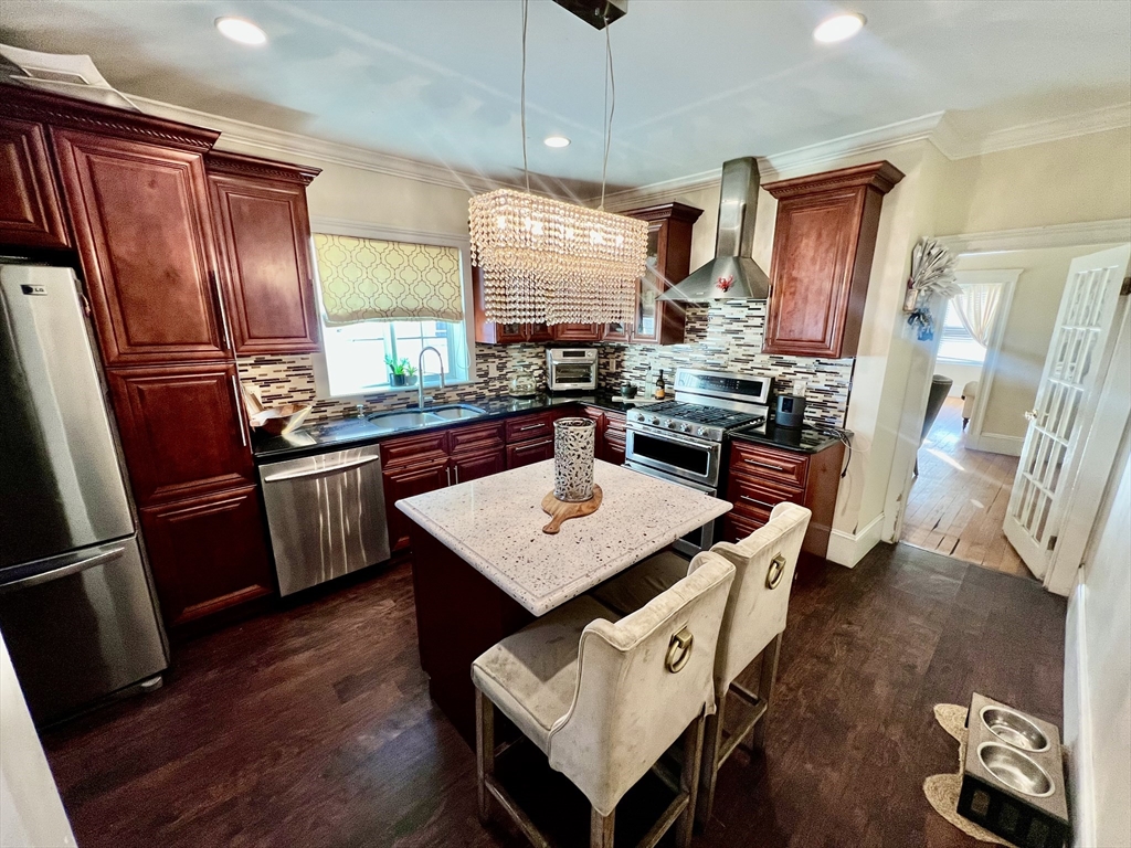 41 Pearl Street, Unit 2 Everett, MA 02149 - Photo 1 of 26 a kitchen with stainless steel appliances granite countertop a refrigerator a sink dishwasher a stove a dining table and chairs with wooden floor