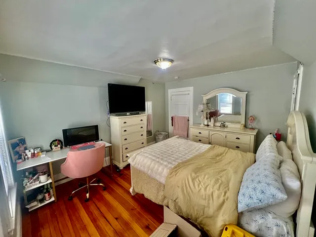 a spacious bedroom with a bed and a flat screen tv