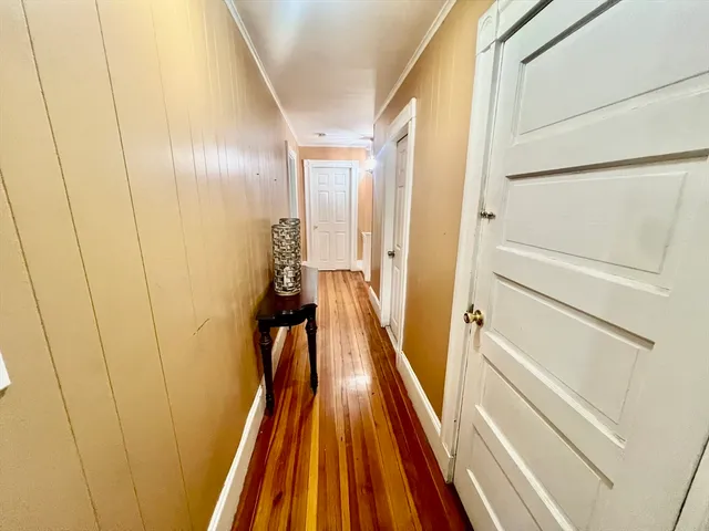 a view of a hallway with wooden floor and staircase