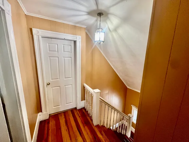 a view of a hallway with wooden floor and staircase