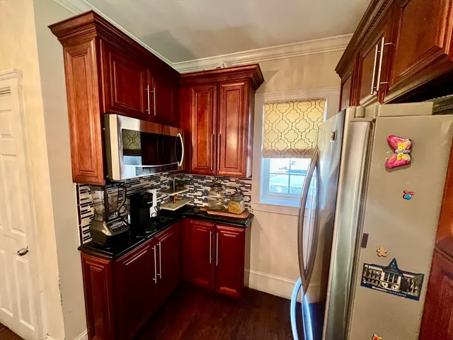 a kitchen with stainless steel appliances granite countertop a refrigerator and a stove
