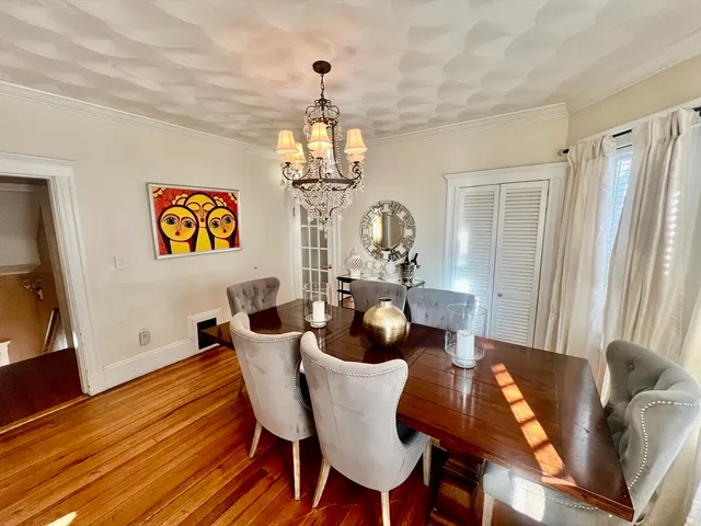 a dining room with furniture a chandelier and wooden floor