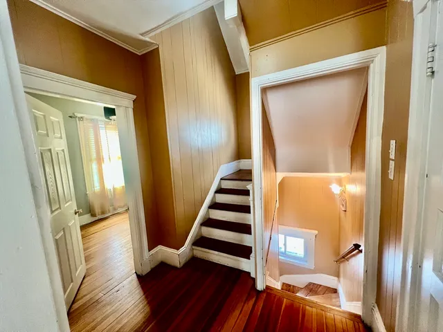 a view of front door with wooden floor and stairs