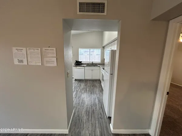 a kitchen with a white cabinets and wooden floor