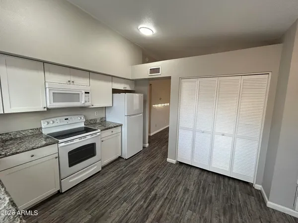 a kitchen with a refrigerator a sink dishwasher with a stove and wooden floor