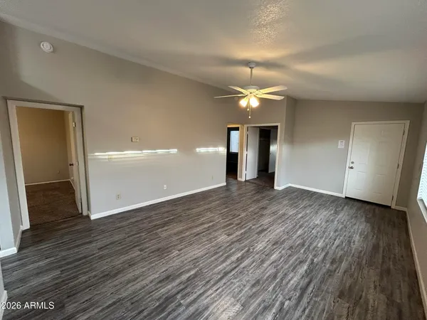 an empty room with wooden floor and windows