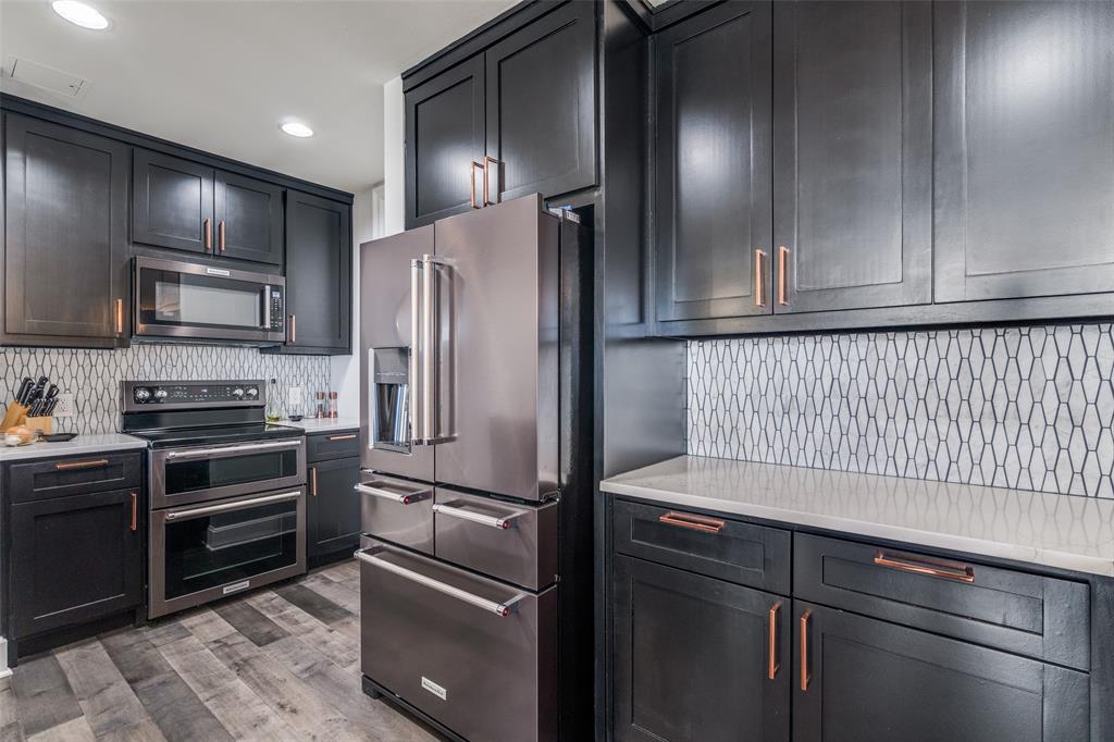 1505 Elm Street, Unit 1504 Dallas, TX 75201 - Photo 5 of 33 Kitchen with decorative backsplash, stainless steel appliances, light stone countertops, light wood-style floors, and recessed lighting