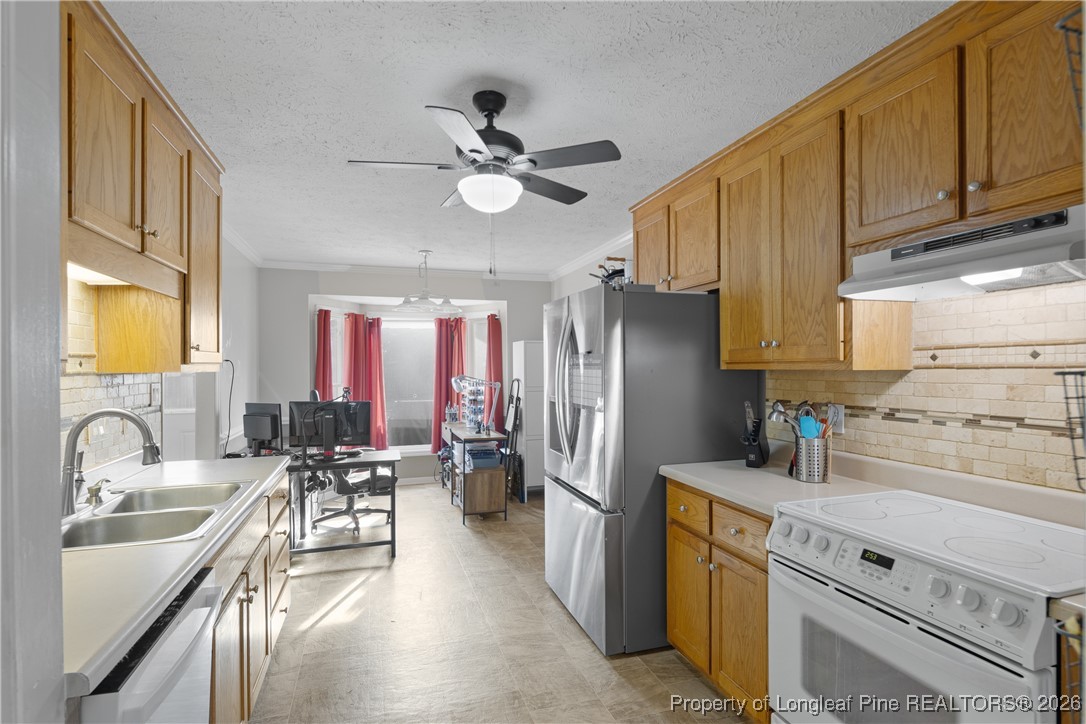 226 Overton Road Raeford, NC 28376 - Photo 5 of 24 a kitchen with stainless steel appliances a sink a stove and a refrigerator with wooden cabinets