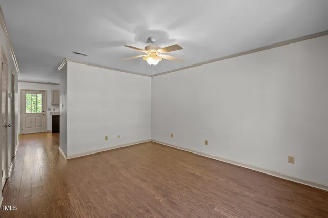 a view of empty room with wooden floor
