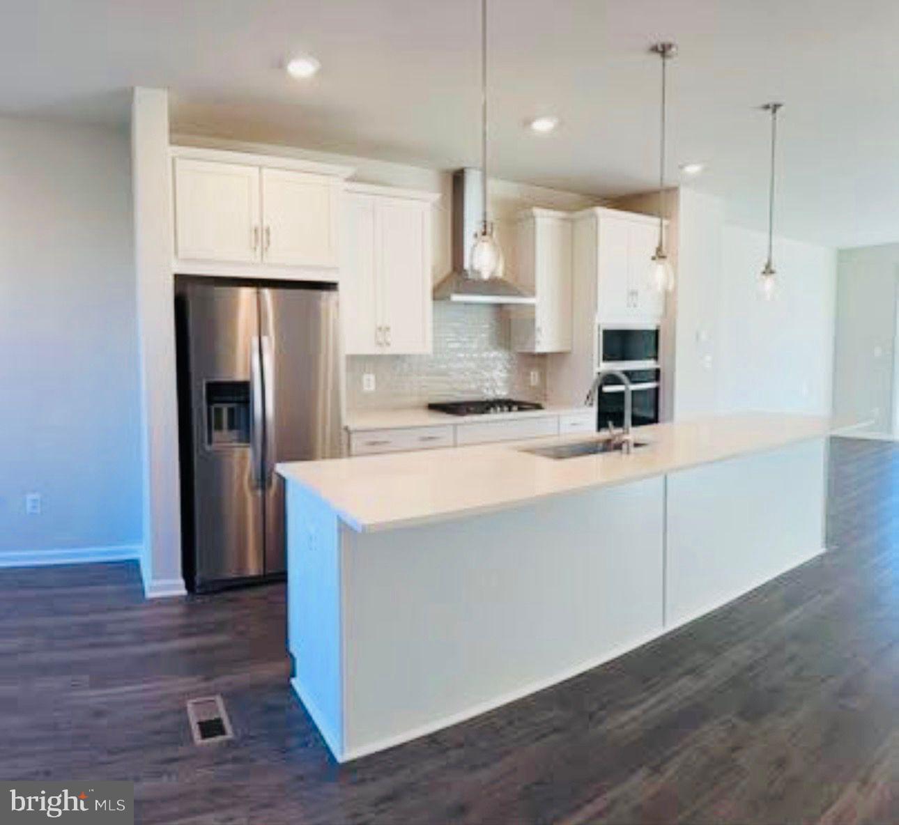 9361 Barnes Loop Manassas, VA 20110 - Photo 3 of 22 a kitchen with kitchen island a refrigerator and a sink