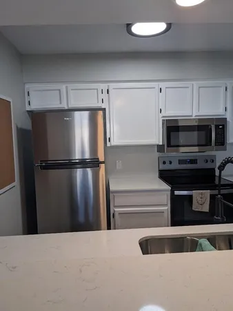 a kitchen with stainless steel appliances a refrigerator and a microwave