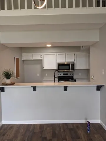 a kitchen with granite countertop a stove and a white cabinets
