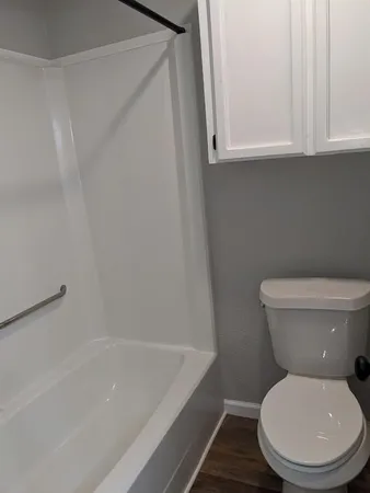 a white toilet sitting next to a bath tub
