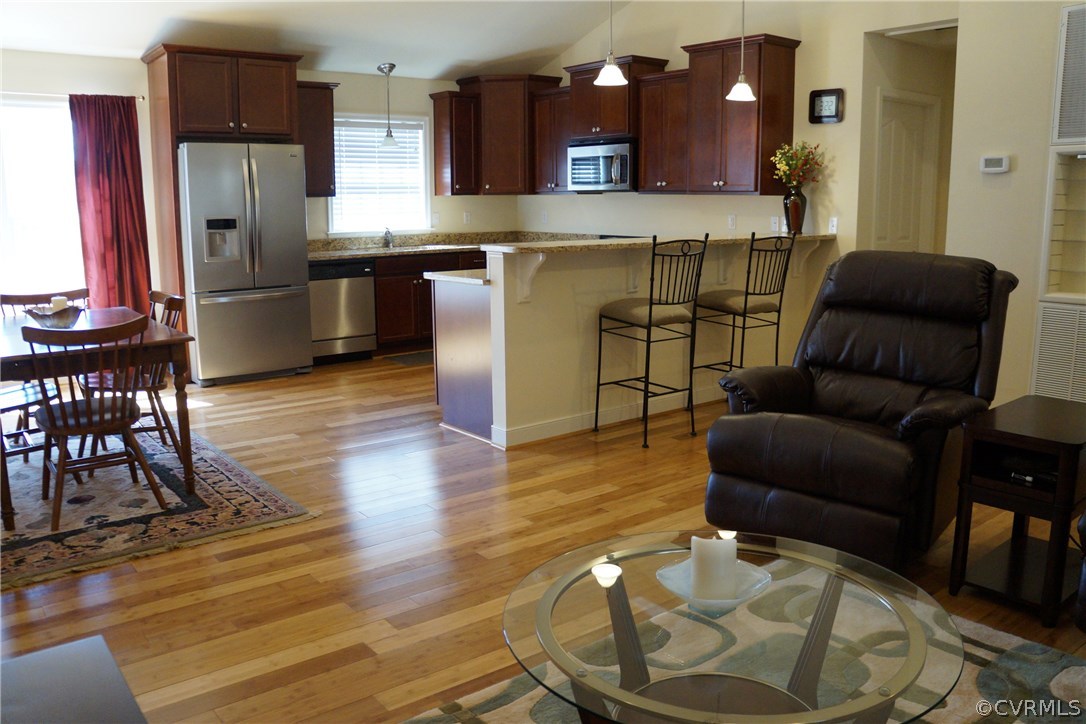 969 Mill Creek Road Meherrin, VA 23954 - Photo 4 of 27 a kitchen with stainless steel appliances granite countertop a refrigerator a stove top oven and a dining table with wooden floor
