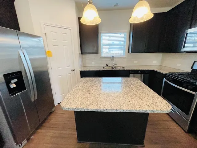 a kitchen with stainless steel appliances a sink stove and refrigerator
