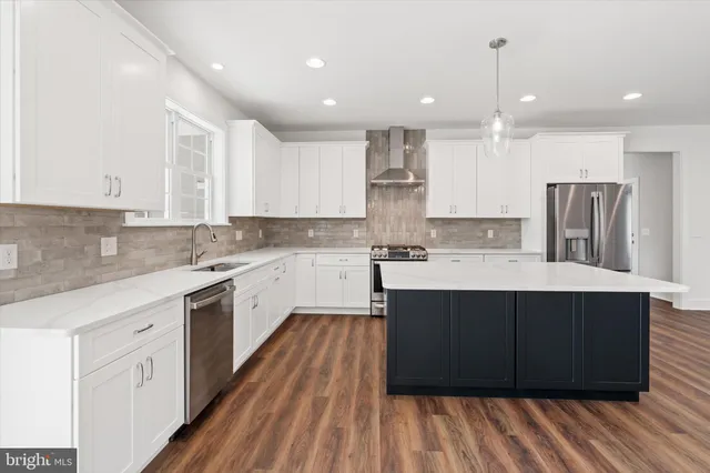 a large kitchen with stainless steel appliances kitchen island granite countertop wooden cabinets and a sink