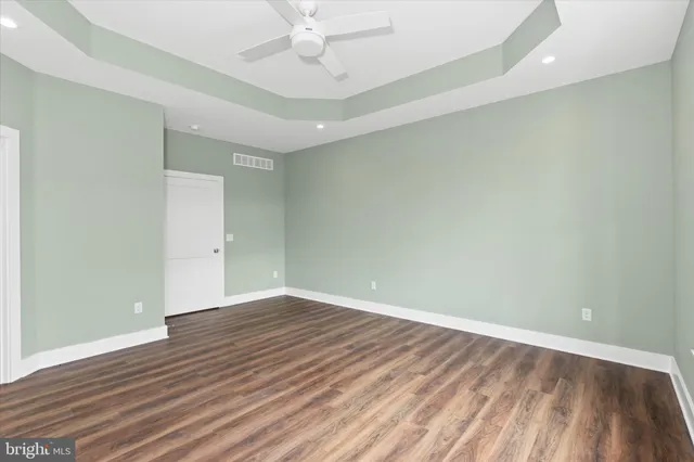 a view of an empty room with wooden floor