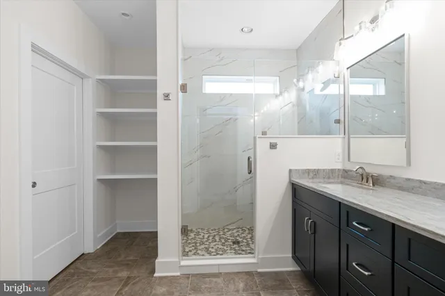 a bathroom with a shower sink and mirror