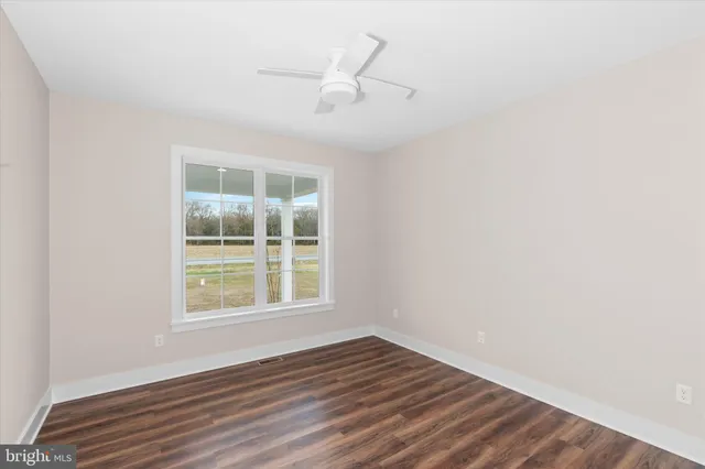 a bathroom with a granite countertop toilet sink and mirror