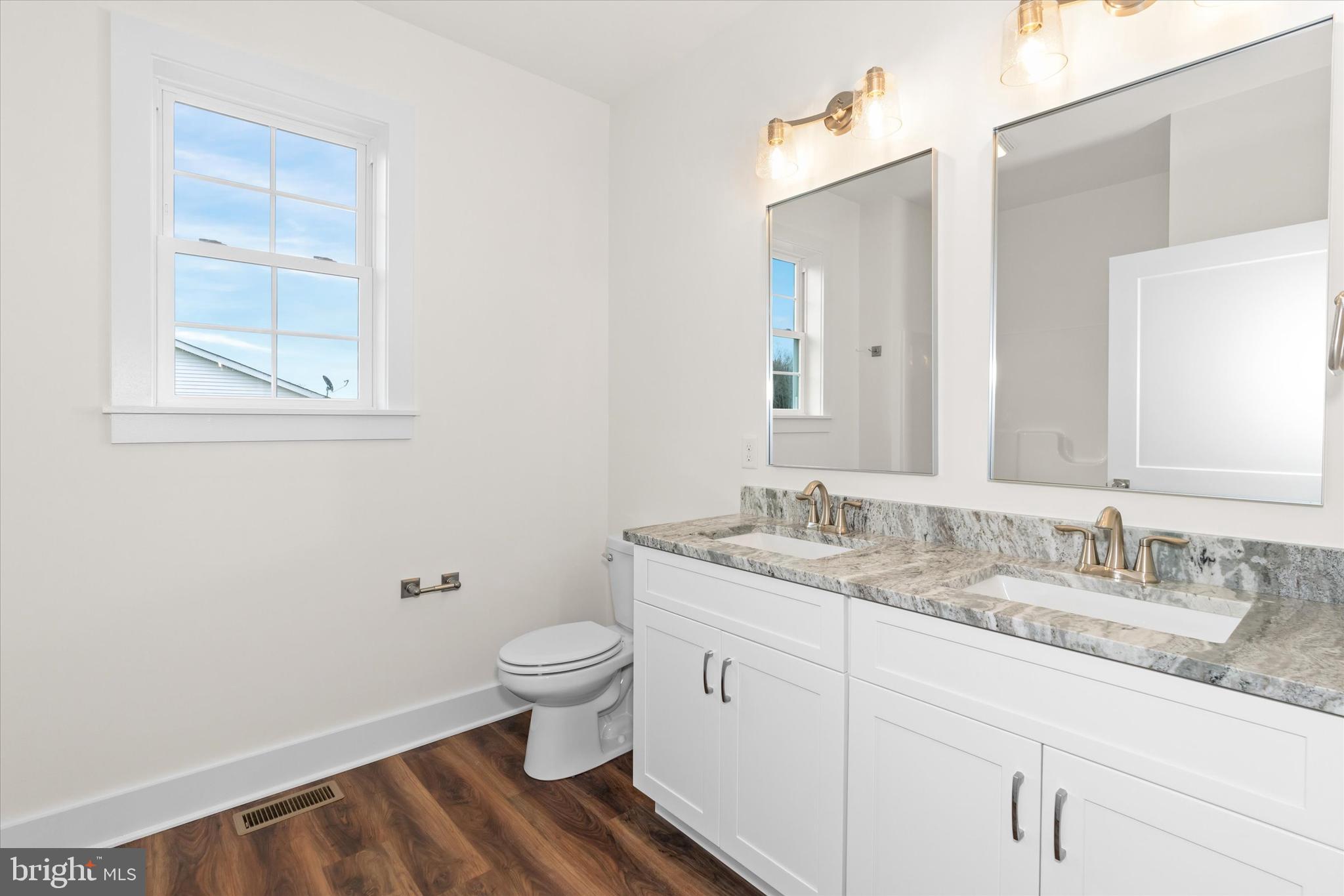 5380 Halltown Road Hartly, DE 19953 - Photo 31 of 45 a bathroom with a granite countertop toilet sink and mirror