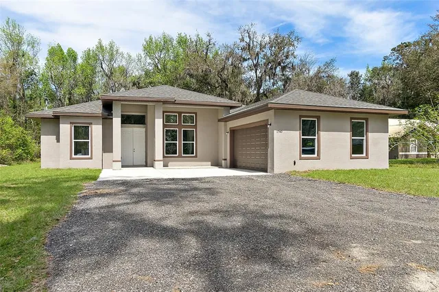 a view of a yard in front of a house with plants and trees