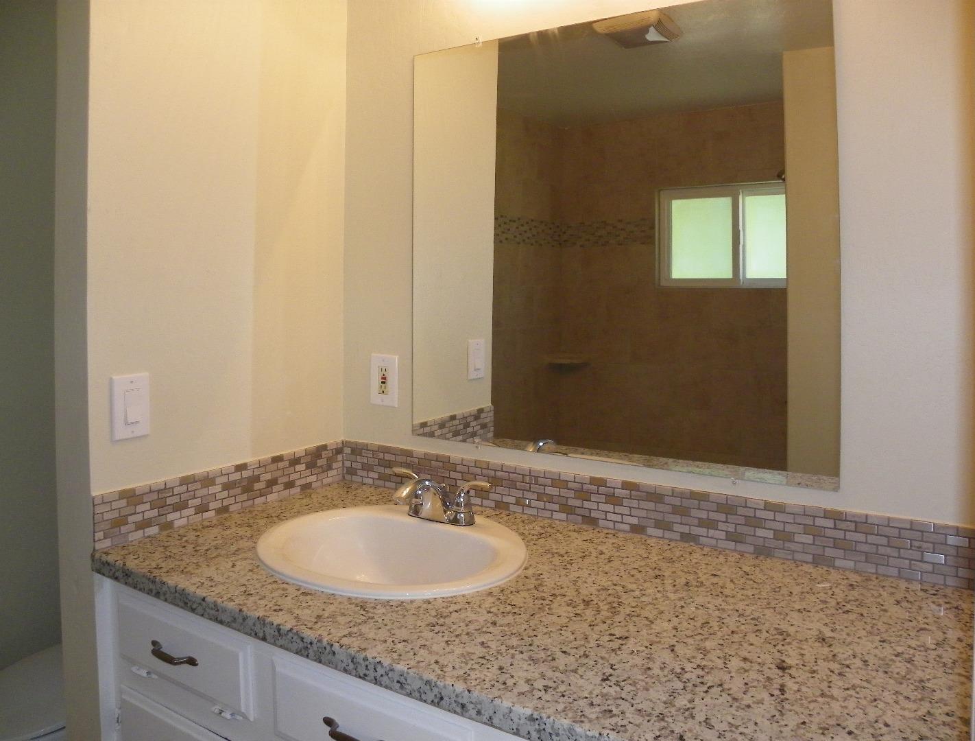 254 Hames Road Corralitos, CA 95076 - Photo 18 of 19 a bathroom with a granite countertop sink and a mirror