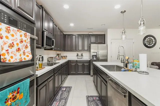 a kitchen with kitchen island granite countertop wooden cabinets a sink a stove and a oven