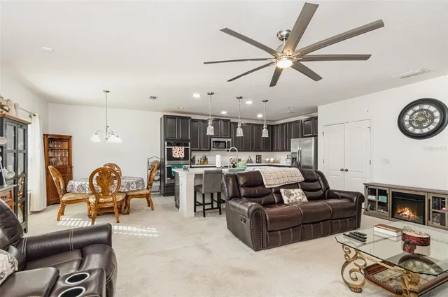 a living room with furniture kitchen view and a window