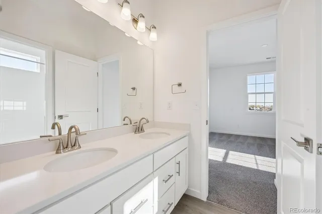 a bathroom with double vanity sink and a mirror