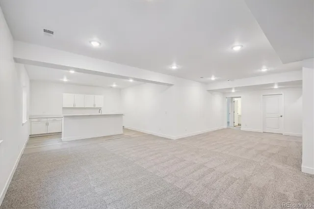 a view of an empty room with a kitchen