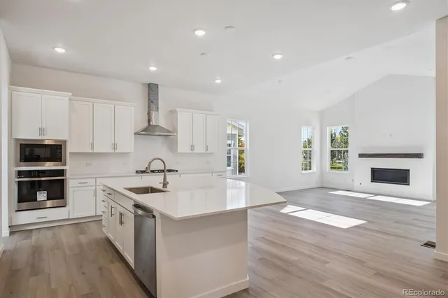 a kitchen with a sink stove top oven and cabinets