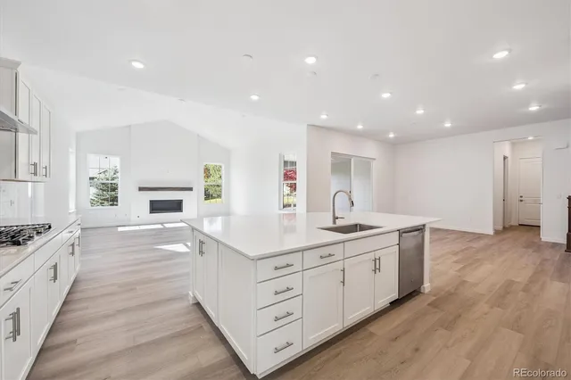 a kitchen with white cabinets appliances and a center island
